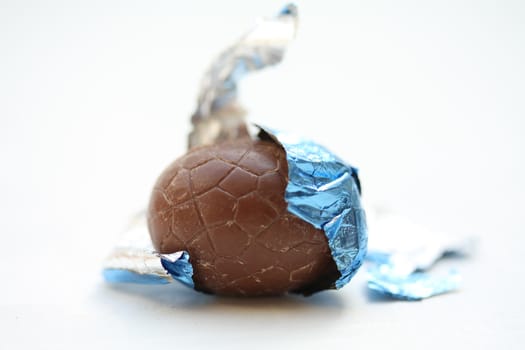 A chocolate easter egg in blue wrapping, close up