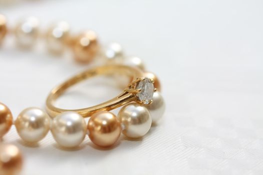 A solitaire diamond engagment ring on a pearl necklace