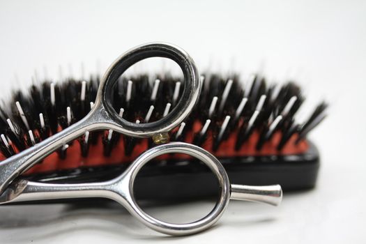 A pair of scissors and a brush in close up - basic hairdressers tools