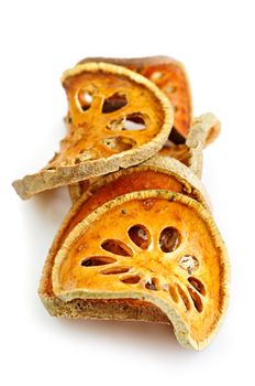 Slices of dried bael fruit on white background