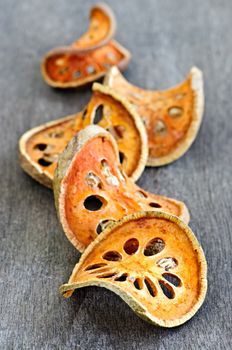 Slices of dried bael fruit on wood surface