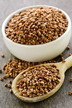 Buckwheat seeds on wooden spoon and in bowl