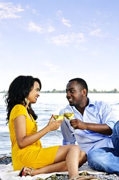 Young romantic couple celebrating with wine at the beach with copyspace