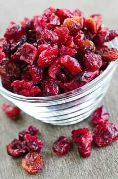Dried cranberries spilling out of glass bowl