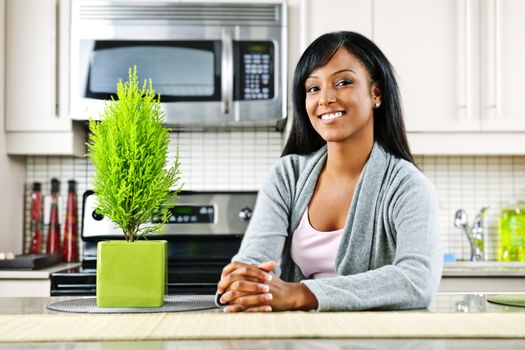 Smiling black woman in modern kitchen interior