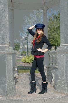 Full-length shot of a beautiful young brunette wearing a stylized costume that's remeniscent of the old British Guard.  The model and her wardrobe are in color; the background has a color pencil sketch effect applied.