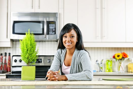 Smiling black woman in modern kitchen interior