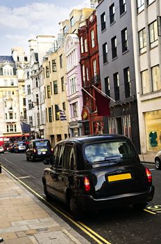 London street with taxicab and shops on sunny day