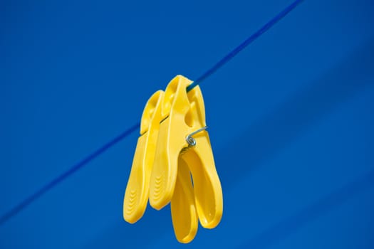 detail of cloth pegs under the clear blue sky