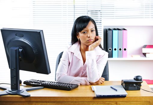 Portrait of young black unhappy business woman at desk in office