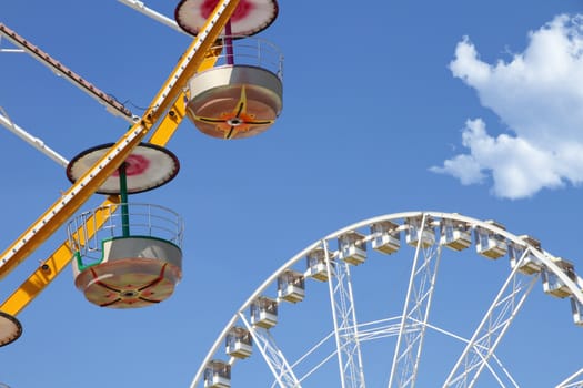 Ferris wheels in an amusement park against blue sky