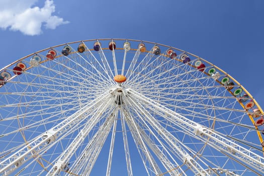 Ferris wheel in an amusement park against blue sky