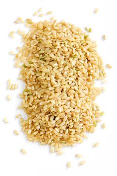 Pile of short brown rice grains isolated on white background