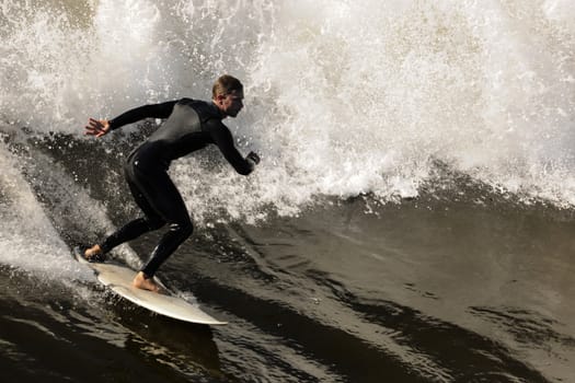 Surfer gets up on a wave. The wave twists with foam and splashes.