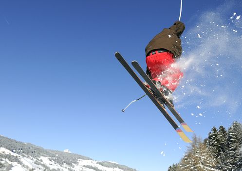 Jumping skier having fun in mountain in winter