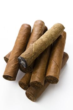 Cuban cigar stack one on top of the other with an unwrapped smoked cigar on top