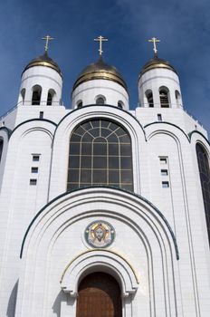 High resolution image. Russian cathedral with gold cupola, bell-tower and icons over entrances.