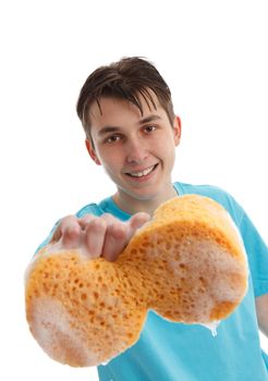 Smiling teen boy using a soapy sponge to wash a car or clean another item.