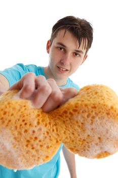 Closeup of an teen boy with outstretched hand holding a soapy sudsy sponge to clean.