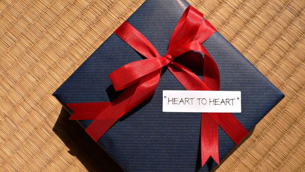 celebration gift with bright red  bow and 'heart-to-heart' words