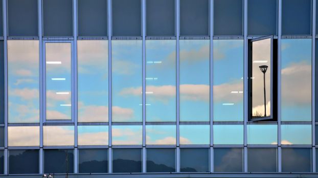 cloudy sky reflection in modern building glass wall