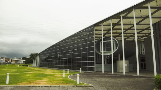 modern architecture exterior: glass wall, hall, environmental lawn and roads