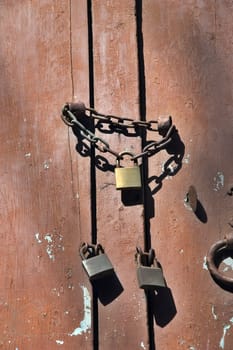 Three locks with chain on peeling door