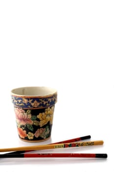 Chopsticks and vase isolated on white
