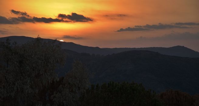 Sun setting behind mountains