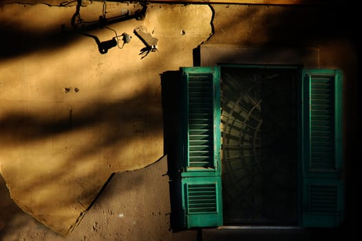 Italian decayed window and wall with long shadows