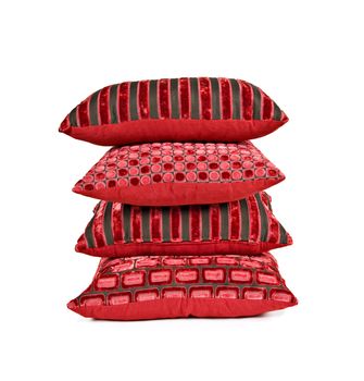 Red cushions stacked up on a white background with space for text