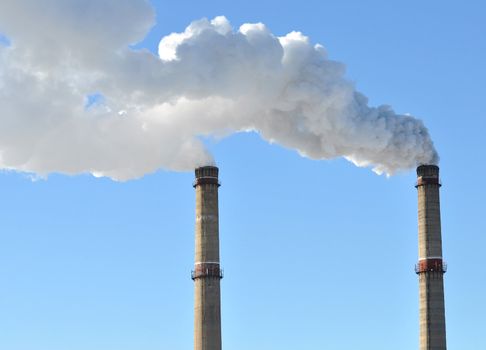 industrial smoke from chimney on blue sky