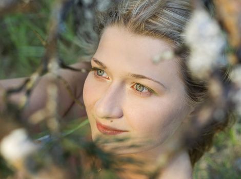 Portrait of natural blond girl with beautiful skin in forest. Close - up.