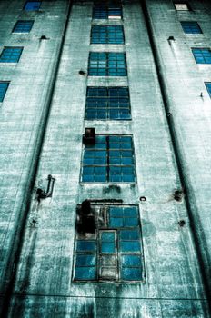 Sinister old abandoned dark blue building with blue windows