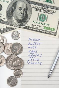 Cost of living. Money, pen and handwritten shopping list.