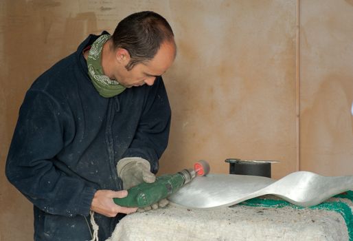Artisan working on a piece of aluminum