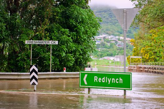 Flooded roundabout, road signs and bridge in Queensland, Australia after heavy rain