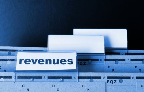 revenue or revenues word on business office folder showing financial success