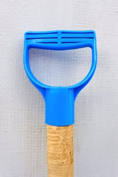 Fragment of handgrip of garden instrument with plastic handle on the walls background