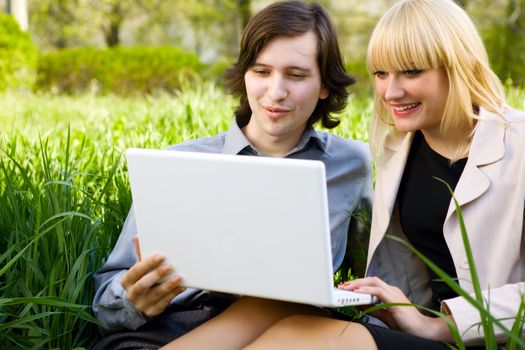 girl and boy laugh with laptop