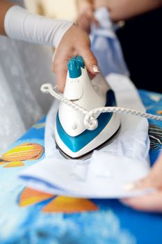 a girl ironing a shirt of a man