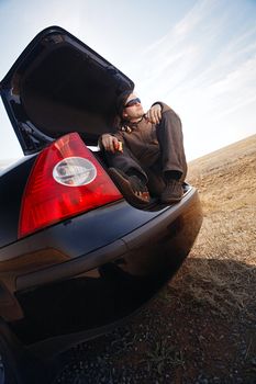 man in trunk of car looking at the sky 