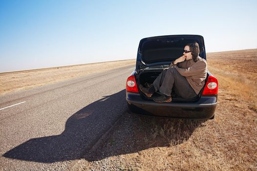 man in trunk of car eating apple