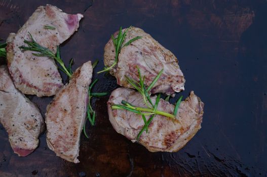 deer meat on bbq flagstone with rosemary