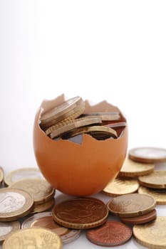coins in an eggshell, metaphor for financial savings,fragile financials,...........