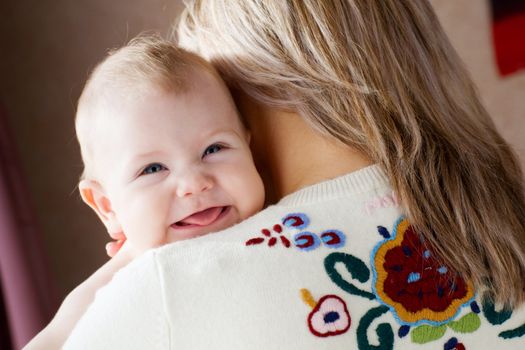 happy child on the shoulder of his mom