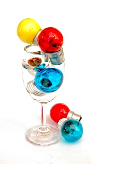 Many colors light bulb in wine glass isolated on white background.