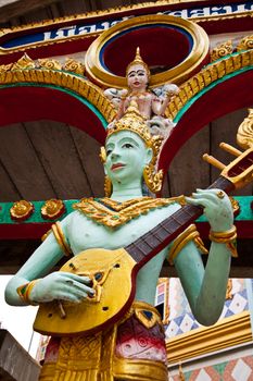 Crying fairy string player stucco in Thai traditional art and craftsmanship at a rural Thai temple.