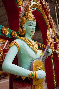 Crying fairy string player stucco in Thai traditional art and craftsmanship at a rural Thai temple.