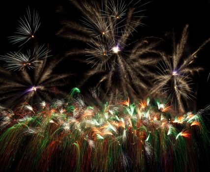 The several fireworks take off to the dark sky then exploded to the harmonize of multi colours dancing flowers.